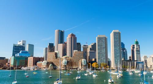 Sailboats in Boston harbor backdropped by city skyline