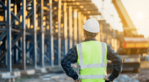 Builder on jobsite looking at scaffolding