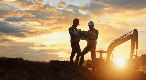 Home builders on jobsite reviewing house plans