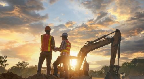 Construction workers look at project