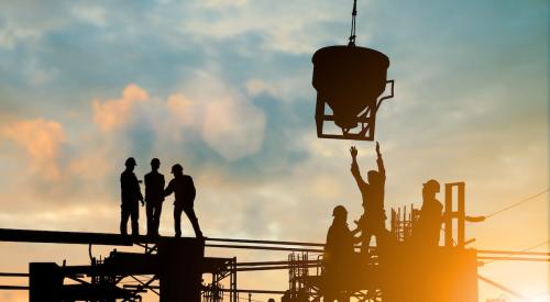 Construction workers lifting equipment onsite