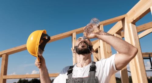 Construction workers pours water on his face to cool down during heatwave