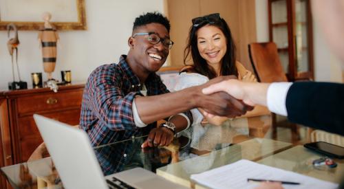 Man shaking hands across a desk with man in suit for a home sale