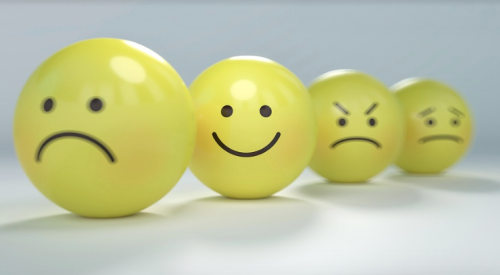 Happy and sad faces on yellow balls