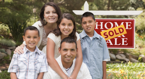 Hispanic family in front of home sale/sold sign