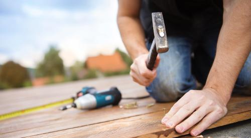 Man hammering nail into board