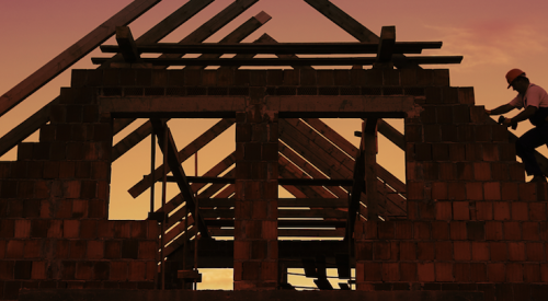 Carpenters frame roof of house at dusk