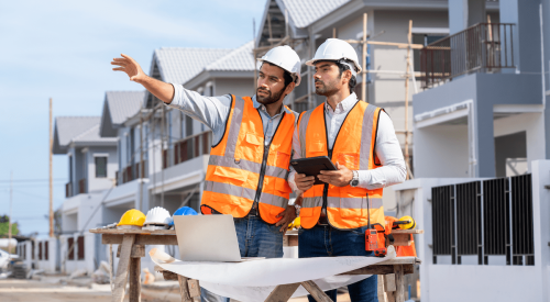 Two home builders on construction site of new homes