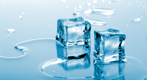 Two ice cubes thawing in puddle of water