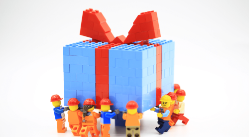 Lego construction workers carry holiday gift