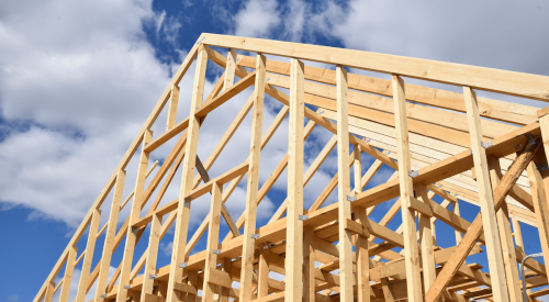 New-home framing with a blue sky behind