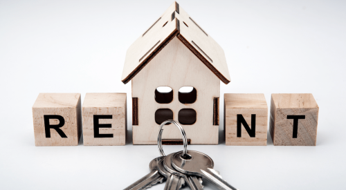 Wooden house model with house keys and RENT letters on wood blocks