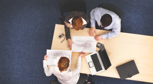 Three people seated at a desk reviewing home plan customizations