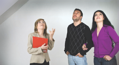 Home salesperson showing a couple inside a new home