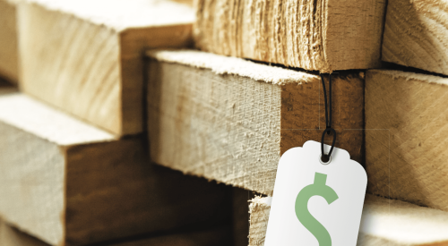 White price tag with green money symbol on stack of lumber