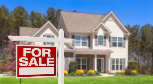 A 'For Sale' sign is in front of a house