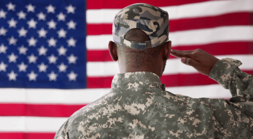 Member of U.S. military salutes American flag