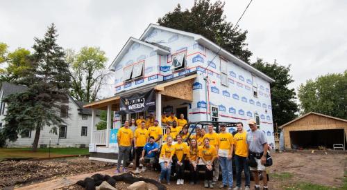 Vikings team next to Habitat for Humanity house in West St. Paul