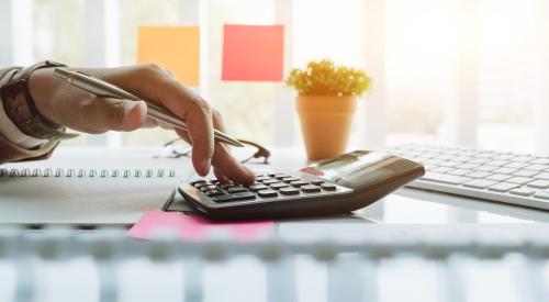 A person types on a calculator.