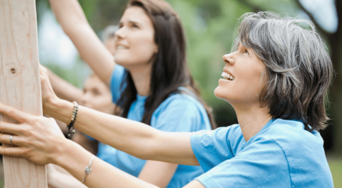 Women volunteers working together to build framing for new home