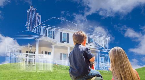 This photo shows a young family looking at an outline of a house.