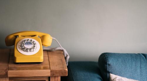 House interior with yellow rotary phone and blue sofa