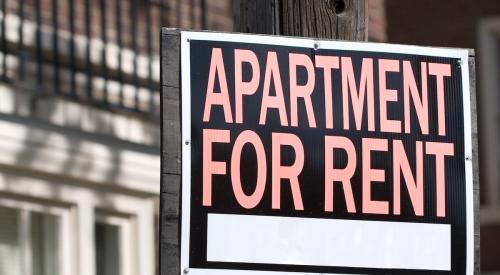 Orange and black 'apartment for rent' sign on light pole