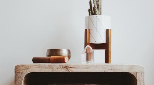 Nightstand with books, singing bowl, quartz, and cactus