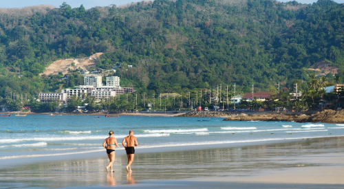 baby boomer couple running on the beach