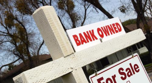 Bank owned sign above house for sale sign