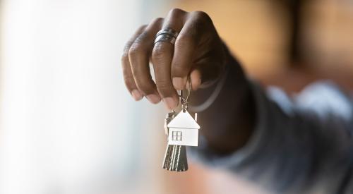 Black appraiser holding silver house keys