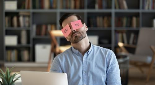 Bored man with open eyes taped to face