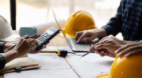 Home builder typing on calculator in office