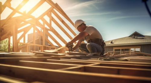 Builder on roof of house under construction