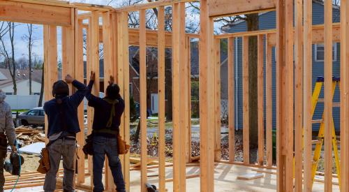 Builders framing new house with wood on jobsite