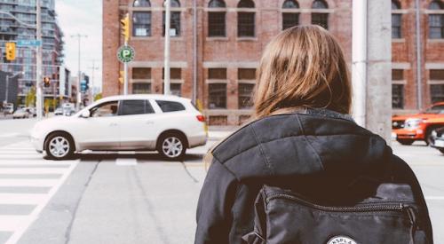 Girl_with_backpack_looking_at_car