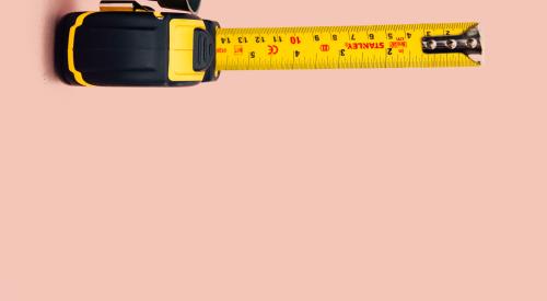 Tape measure on pink background