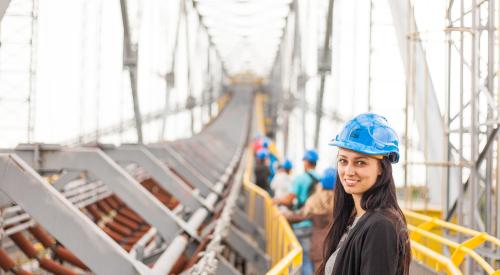 Woman wearing hard hat on construction site 