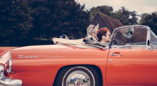 Two adults in red vintage thunderbird