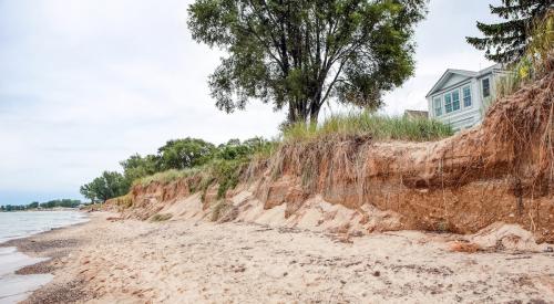 Coastal home next to shoreline being washed away