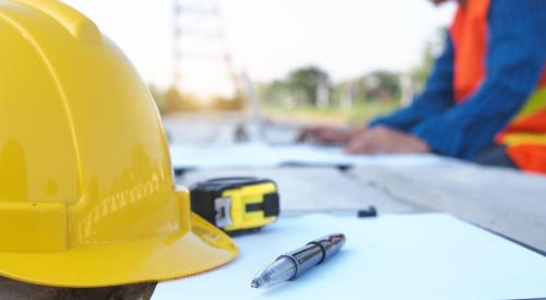 Construction trainee with hard hat taking notes