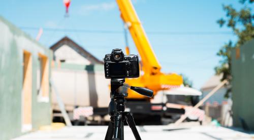 Filming video on tripod on construction site