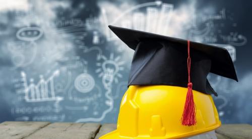 Graduation cap on top of construction hardhat with chalkboard in background