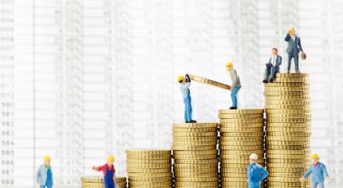 Small construction worker figurines stacking coins