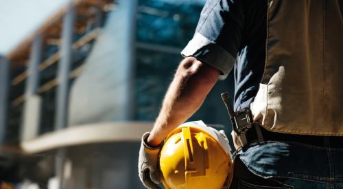 Construction worker holding yellow hard hat