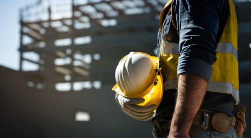 Construction worker holding yellow hard hat