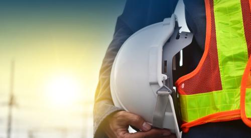 Construction worker with hard hat tucked under his arm