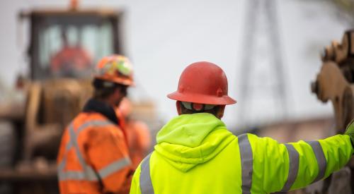 Construction worker in orange helmet and yellow vest