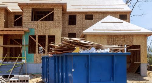 Construction waste in jobsite dumpster in front of a new single-family home is not Lean construction