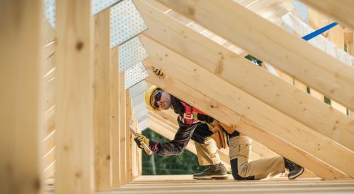 Contractor at work beneath wood roof frame